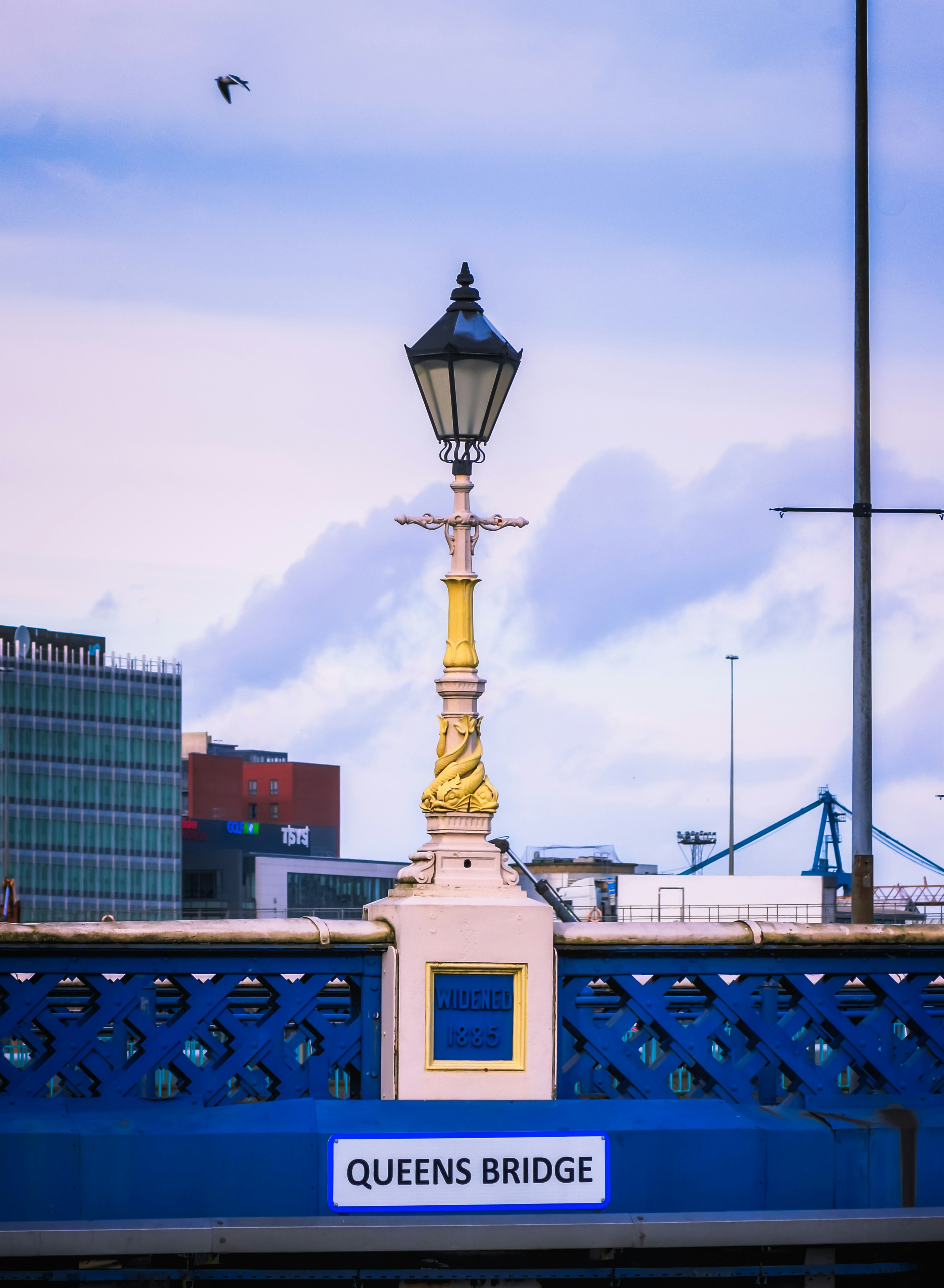 gold statue near city buildings during daytime